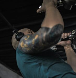 A man with a tattoo on his arm holding a gun